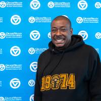 Gentleman standing in front of GV backgroup and smiling at camera